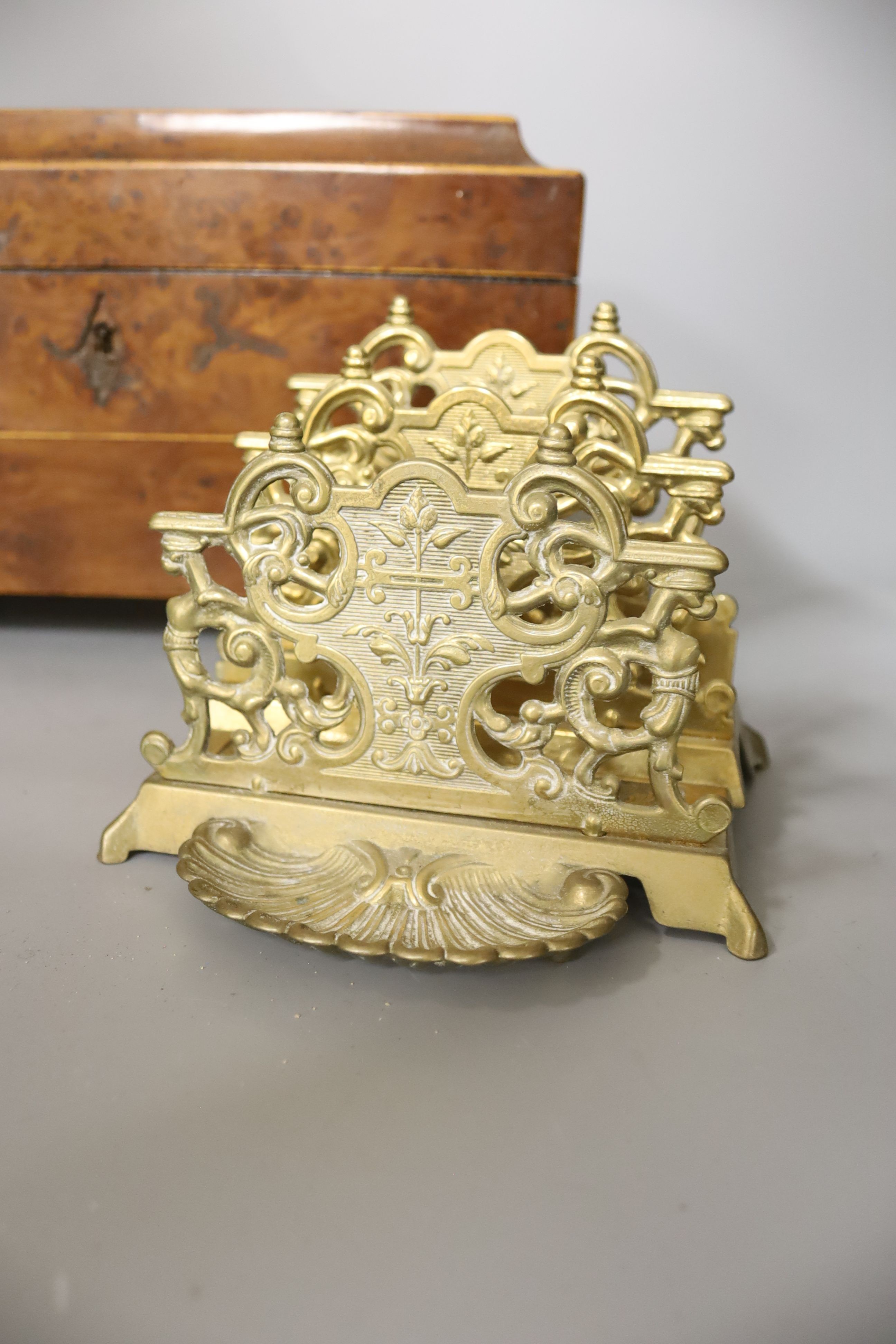 A late Georgian burr yew tea caddy, on gilt metal lion’s paw feet (lacking interior), 31 x 20cm, and a cast brass letter rack (2)